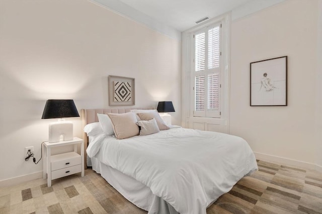 bedroom featuring light colored carpet, baseboards, and visible vents