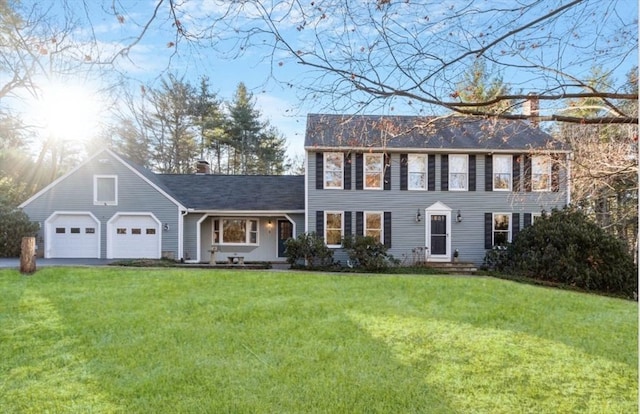 colonial-style house featuring a front lawn and a garage