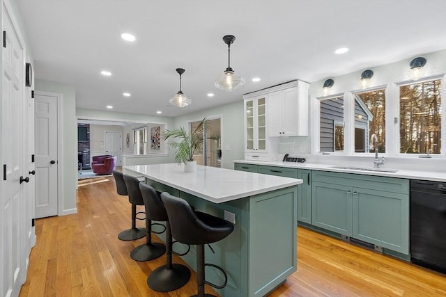 kitchen featuring sink, hanging light fixtures, black dishwasher, green cabinets, and white cabinets