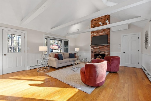 living room featuring a healthy amount of sunlight, an AC wall unit, a fireplace, and a baseboard radiator