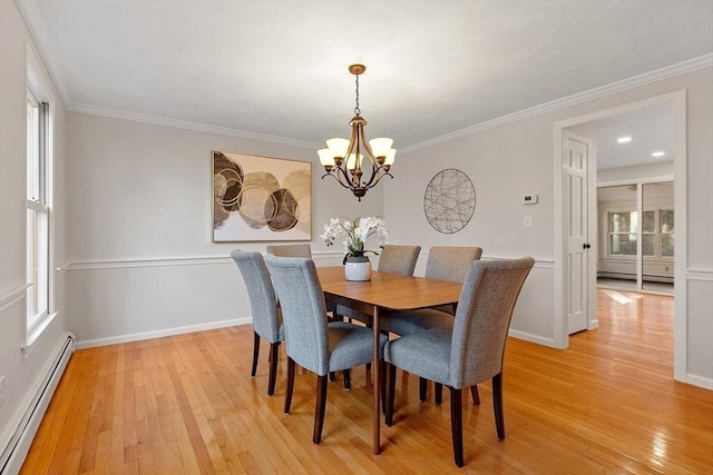 dining area with crown molding, light hardwood / wood-style flooring, a chandelier, and a baseboard heating unit