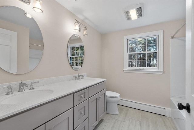 bathroom with toilet, vanity, and a baseboard heating unit