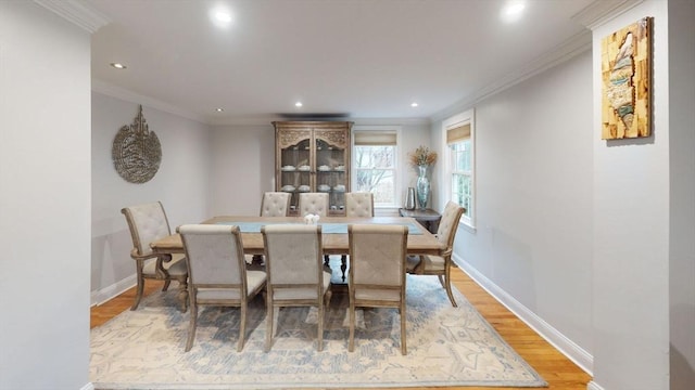 dining space with wood-type flooring and crown molding