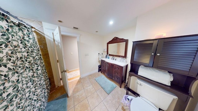 bathroom with walk in shower, vanity, toilet, and tile patterned flooring