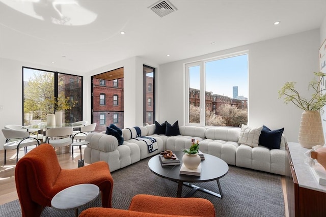 living room with a healthy amount of sunlight, visible vents, and recessed lighting
