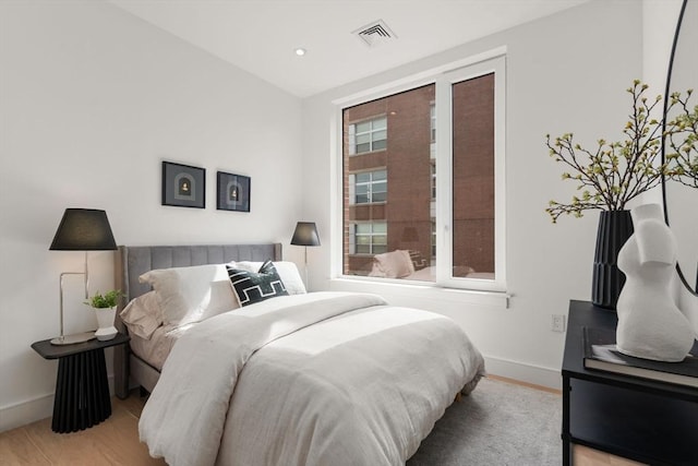 bedroom featuring baseboards, wood finished floors, visible vents, and recessed lighting