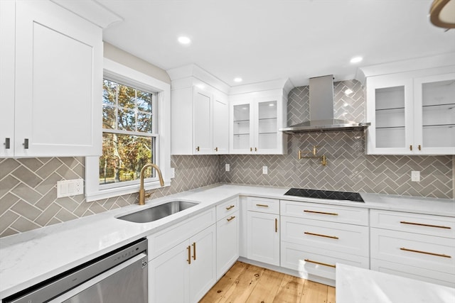 kitchen featuring light wood-type flooring, stainless steel dishwasher, black electric cooktop, sink, and wall chimney range hood