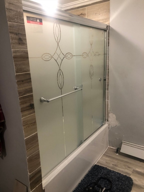 bathroom featuring hardwood / wood-style flooring and combined bath / shower with glass door