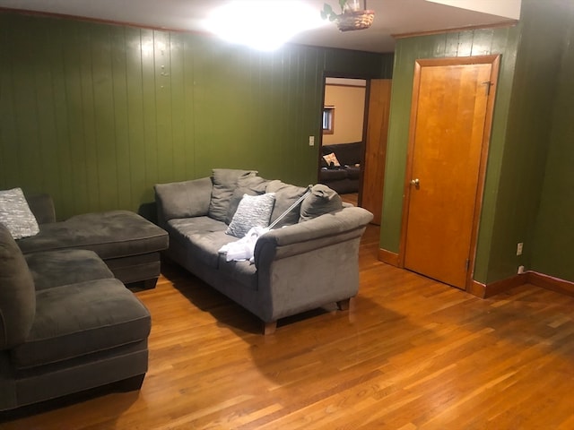 living room with light wood-type flooring and wooden walls