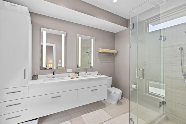 bathroom featuring vanity, a shower with shower door, and toilet