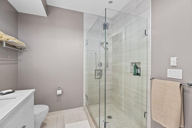 bathroom featuring toilet, an enclosed shower, and vanity