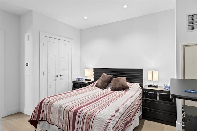 bedroom with a closet and light hardwood / wood-style flooring