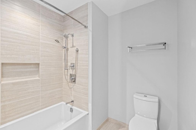 bathroom featuring toilet and tiled shower / bath