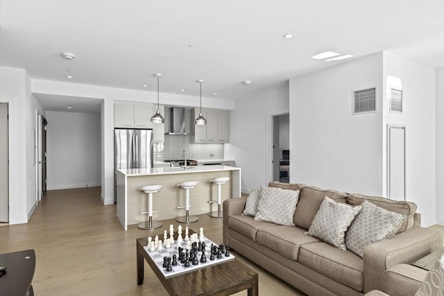 living room featuring sink and light hardwood / wood-style floors