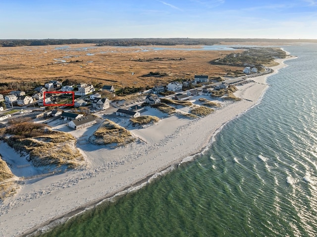 birds eye view of property with a water view and a beach view