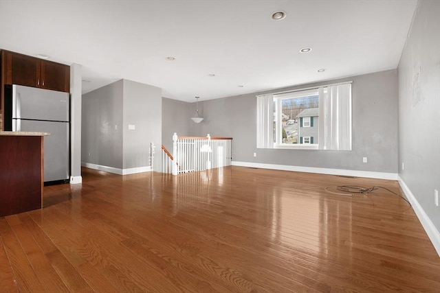 spare room featuring recessed lighting, wood finished floors, and baseboards