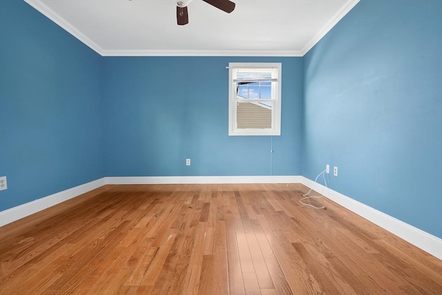 empty room featuring ceiling fan, crown molding, baseboards, and hardwood / wood-style flooring