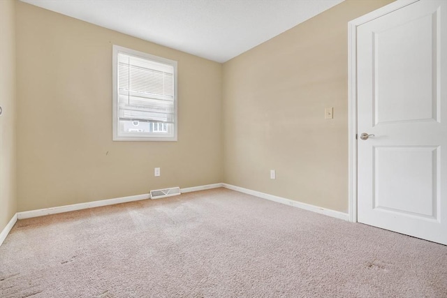 empty room with baseboards, visible vents, and carpet flooring