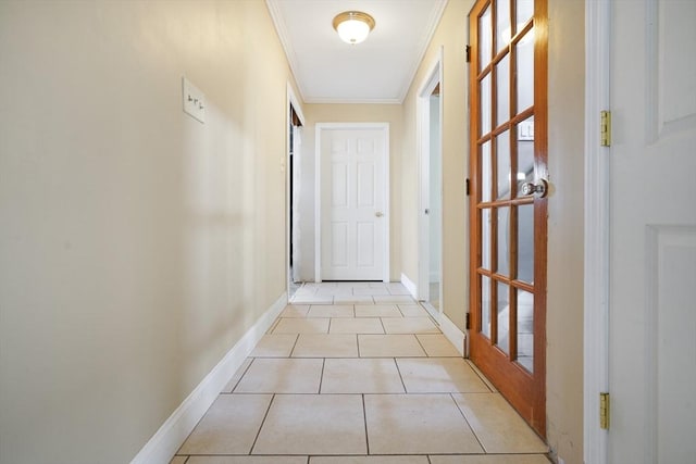 entryway with baseboards, light tile patterned flooring, and crown molding