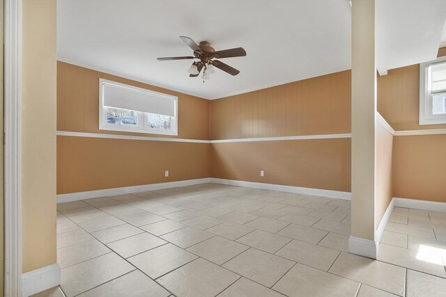 spare room with a healthy amount of sunlight, ceiling fan, baseboards, and light tile patterned flooring