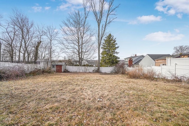 view of yard with an outbuilding, a shed, and a fenced backyard