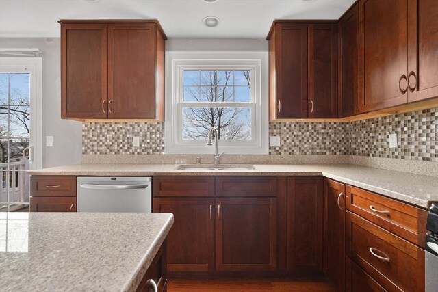 kitchen featuring tasteful backsplash, stove, a sink, light countertops, and stainless steel dishwasher