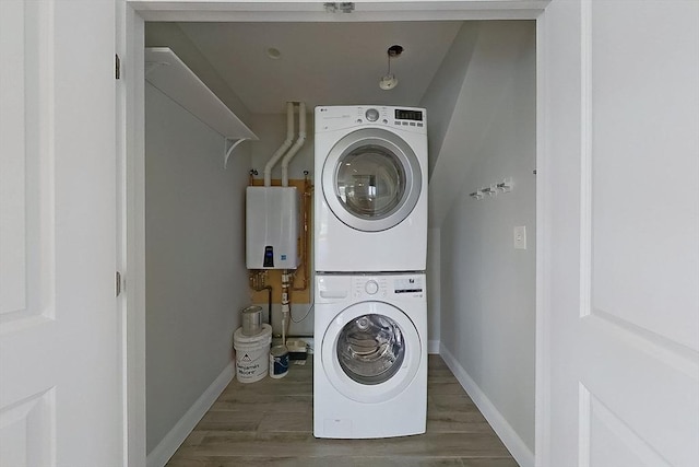 1089 Winthrop Ave Unit A, Revere, MA 02151 - washroom featuring stacked washer / drying machine, baseboards, and wood finished floors