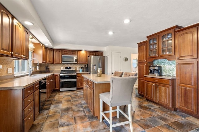 40 Fowler Ave, Revere, MA 02151 - kitchen with stainless steel appliances, a sink, tasteful backsplash, glass insert cabinets, and a kitchen island