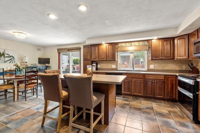 40 Fowler Ave, Revere, MA 02151 - kitchen featuring stainless steel appliances, a kitchen breakfast bar, decorative backsplash, a center island, and recessed lighting