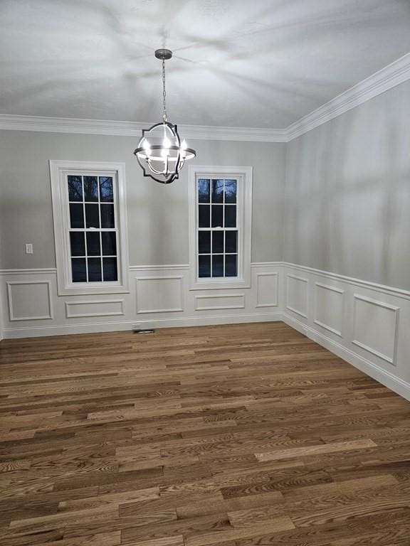 unfurnished dining area featuring crown molding and an inviting chandelier