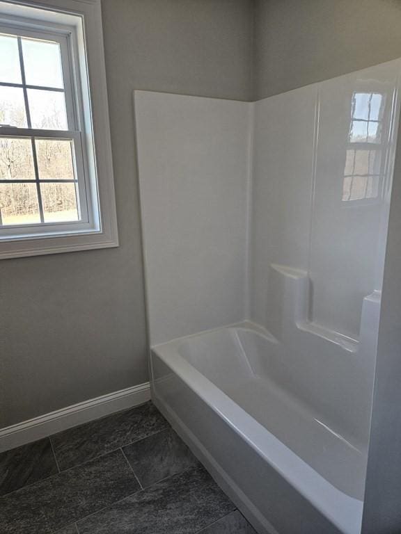 bathroom featuring tile patterned flooring, shower / tub combination, and a healthy amount of sunlight