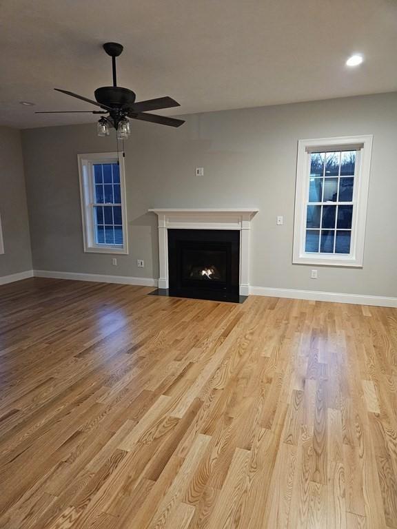 unfurnished living room with ceiling fan and light wood-type flooring