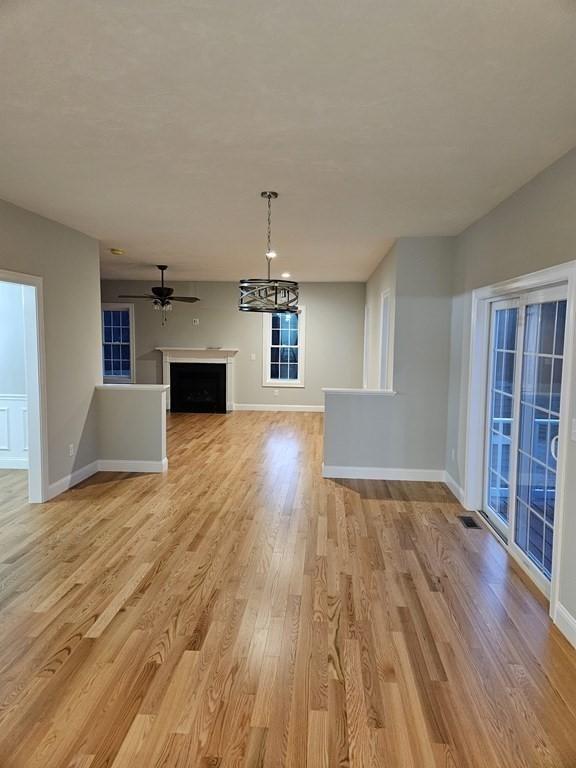 unfurnished living room featuring ceiling fan and light hardwood / wood-style floors