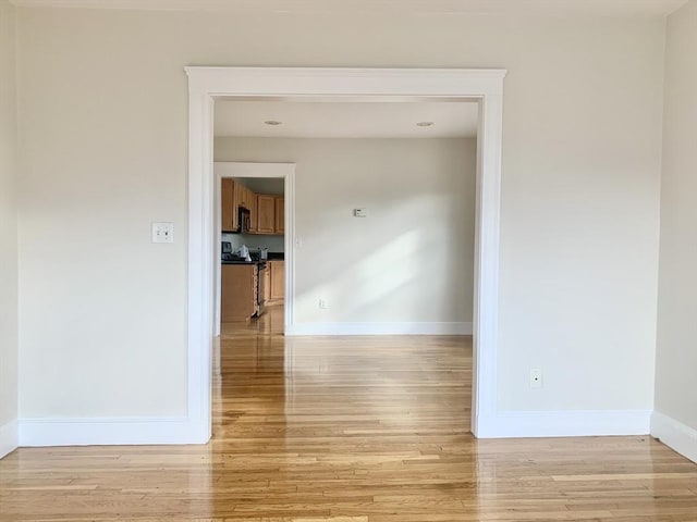 unfurnished room featuring light wood-type flooring and baseboards