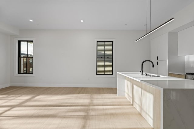 clothes washing area featuring sink and light wood-type flooring