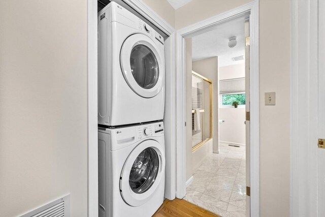 289 Market St Unit B, Boston, MA 02135 - laundry room with stacked washer / drying machine, light marble finish flooring, and baseboards