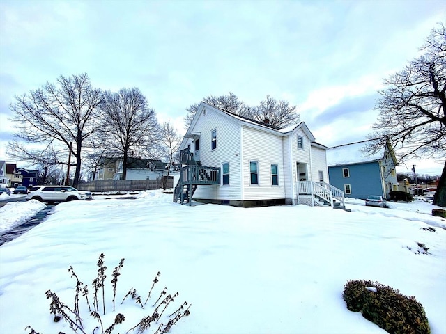 snow covered property with fence