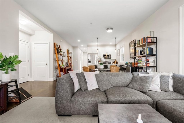 living area with dark wood-type flooring and recessed lighting