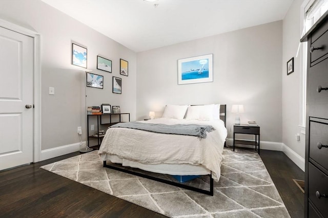 bedroom with baseboards and wood finished floors