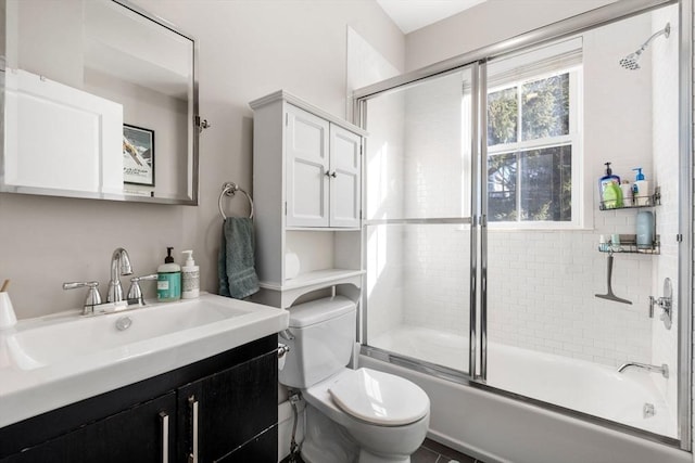 full bath with enclosed tub / shower combo, vanity, and toilet