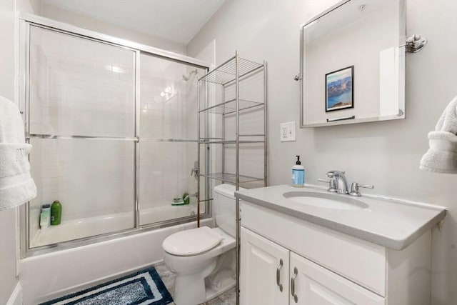 bathroom with toilet, enclosed tub / shower combo, and vanity