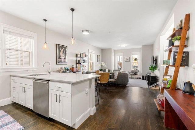 kitchen featuring dark wood finished floors, open floor plan, white cabinetry, a sink, and dishwasher