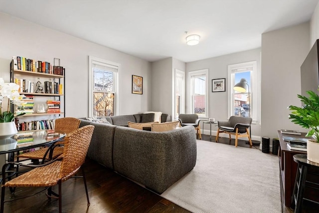 living room with baseboards and dark wood-type flooring