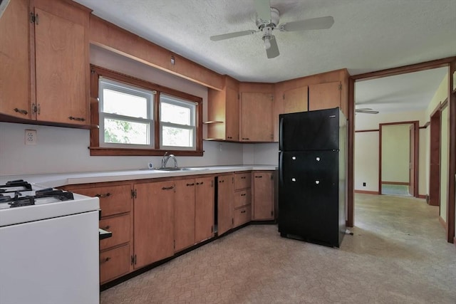 kitchen with black fridge, white gas range, a textured ceiling, ceiling fan, and sink