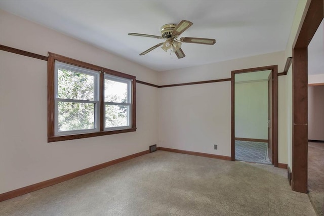 spare room featuring light carpet and ceiling fan