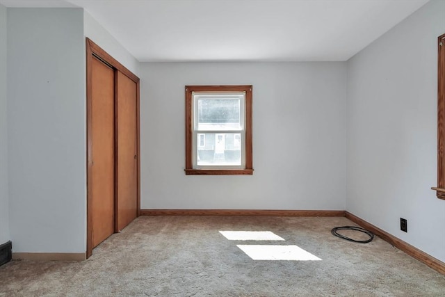 unfurnished bedroom with light carpet and a closet