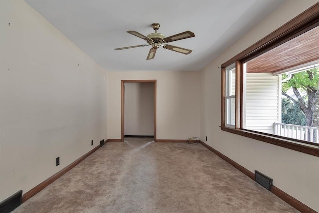 spare room with ceiling fan and light carpet