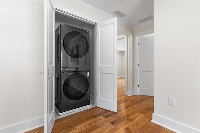 14 Corcoran Rd, Burlington, MA 01803 - laundry room featuring estacked washer and dryer, ornamental molding, and wood finished floors