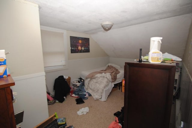 bedroom with carpet floors and lofted ceiling