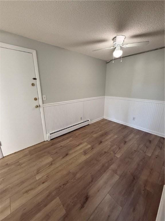 spare room featuring a baseboard radiator, a textured ceiling, ceiling fan, and dark hardwood / wood-style flooring